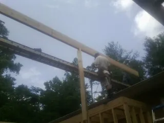 Carpenter setting a ridge beam over a new addition frame — Ice Dam Removal by Roofing Brothers in Geneseo