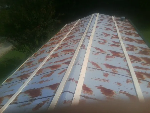 Rusted metal roof panels with new wood purlins before replacement — Storm Damage Roof Repair in Geneseo by Roofing Brothers
