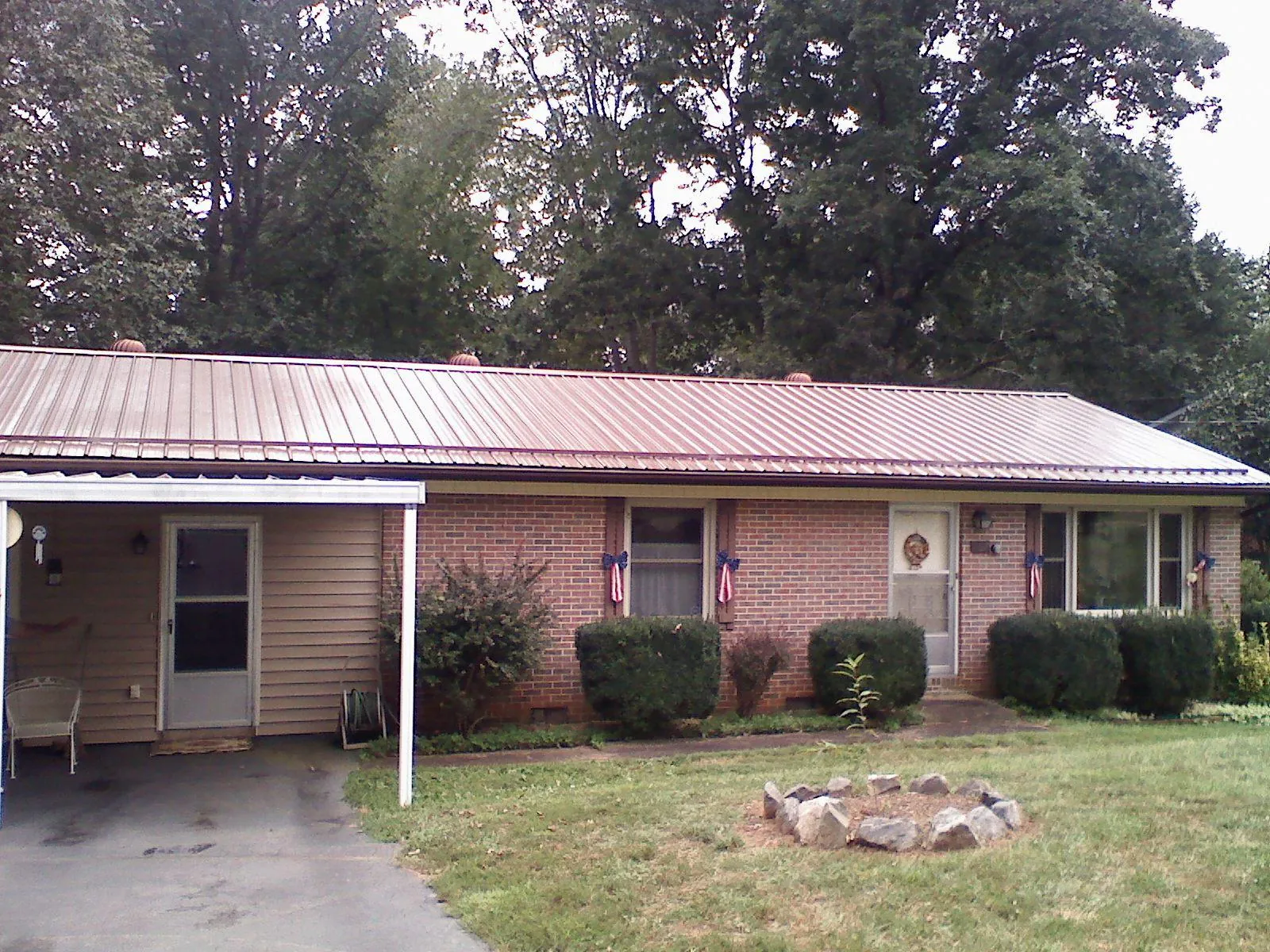 Bronze metal roof and carport on a brick ranch home — Roof Repair work by our crew in Geneseo